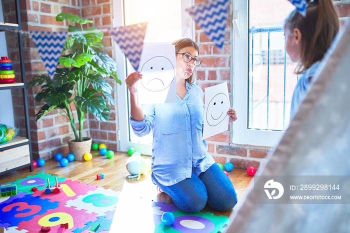 Young therapist woman speaking and treating child, counselor and behaviour correction at pedagogue payroom showing happy and sad faces