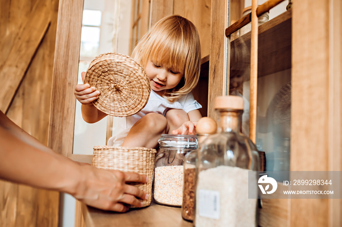 Little girl helps mom in the kitchen with household chores