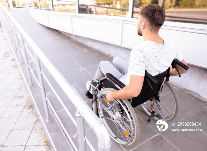 Young man in wheelchair on ramp outdoors