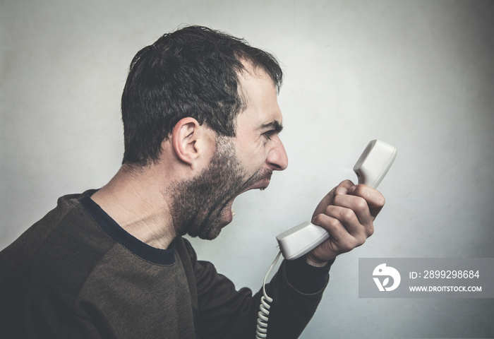 Angry man shouting on phone.