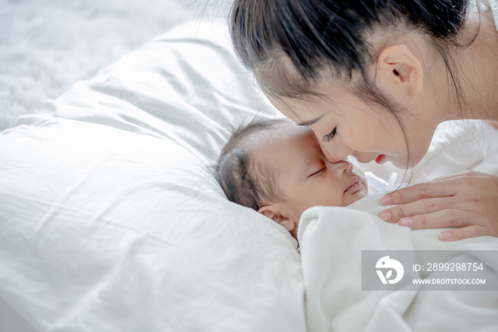 baby sleeps asian mother and touches her child with tenderness and cherishness