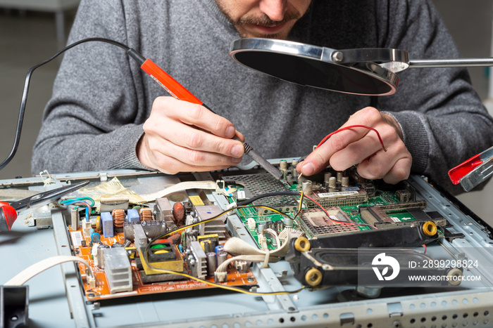 man repairing or soldering an electronic appliance or product. close up image