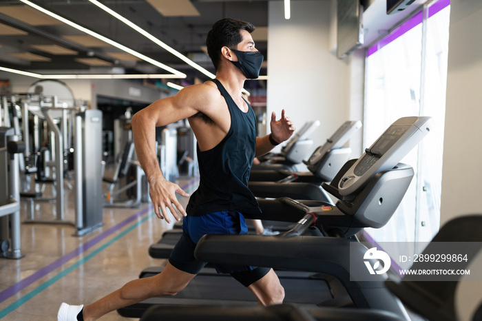 Strong young latin man focused on running in a treadmill