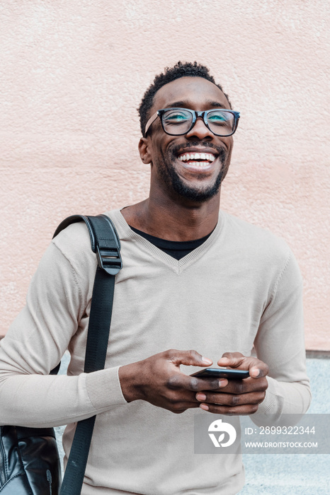 英俊的非裔美国人拿着智能手机微笑