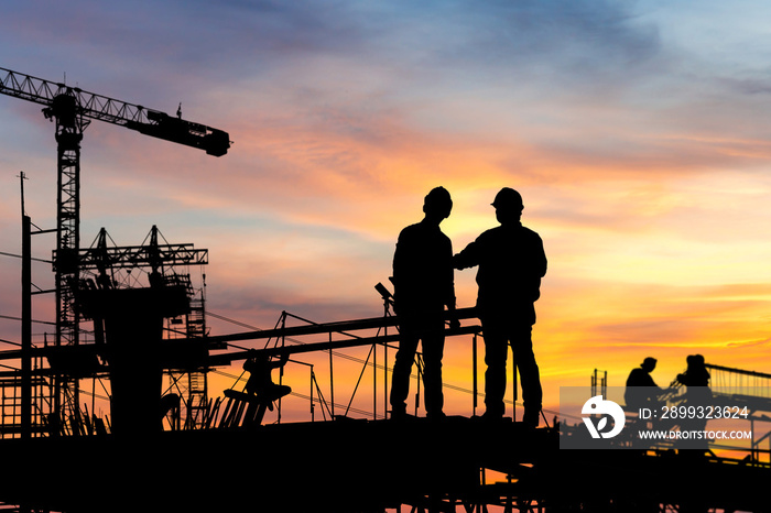 Silhouette of Engineer and worker checking project at building site background, construction site at