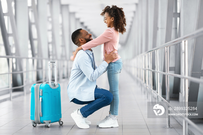 Happy black dad meeting daughter in airport