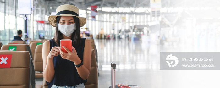 New normal travel of traveler asian woman with mask using mobile phone in airport Thailand