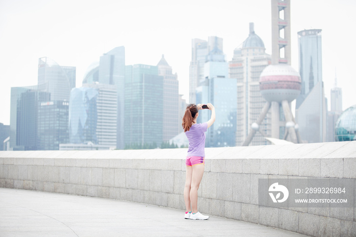 年轻女子在中国上海浦东拍摄建筑