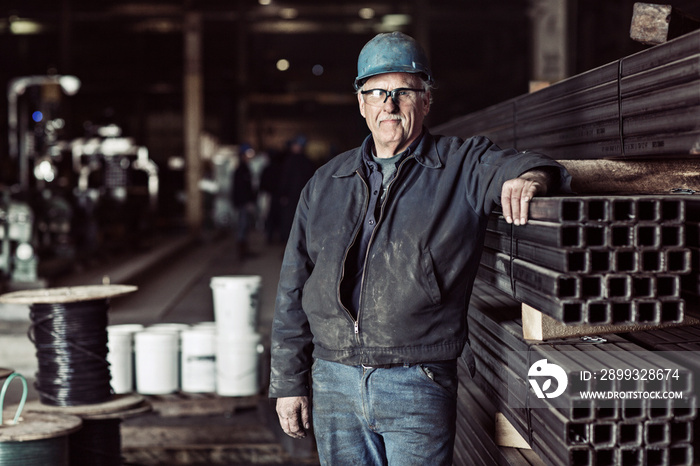 Portrait of senior steel worker standing in factory