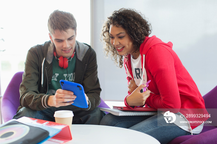 Young college students with digital tablet studying in student lounge