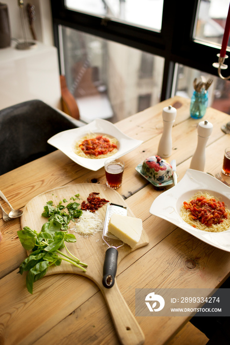 Freshly baked spaghetti and ingredients on table