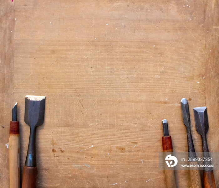 two gravers and three chisels on a wooden board ２本の彫刻刀と３本の鑿と木のボード