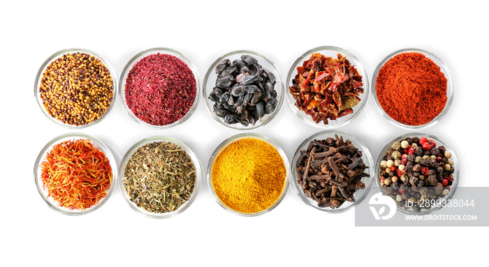 Assortment of spices in glass bowls on white background