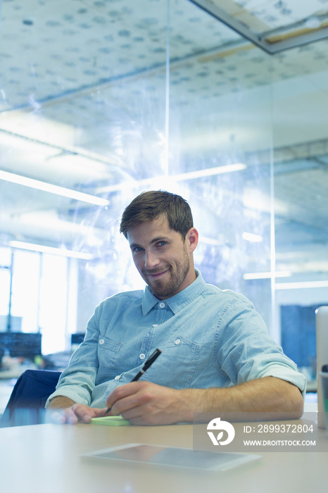 Portrait confident businessman taking notes in office