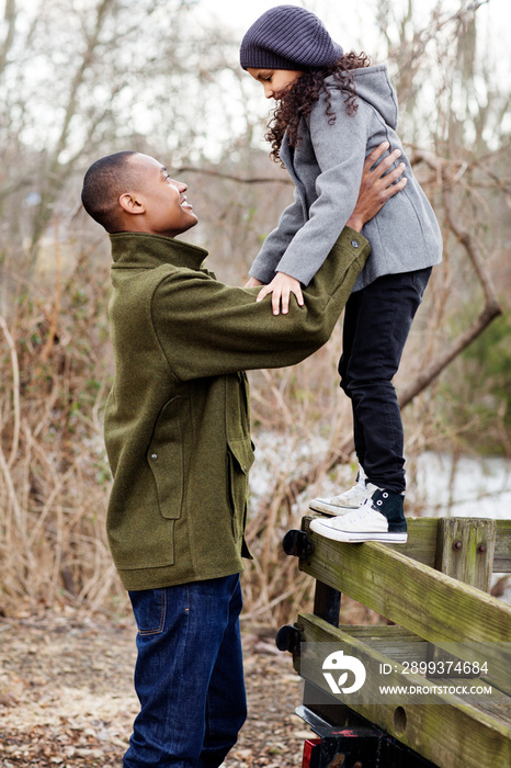 Father supporting his daughter (6-7) standing on cart