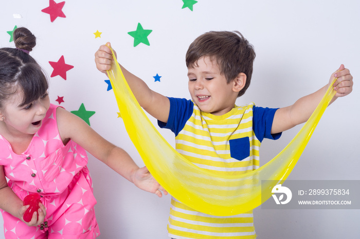 Kid playing hand made toy called slime. Children play with big yellow slime. Kid squeeze and stretch