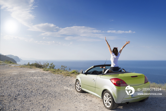 Young woman drive a car on the beach.