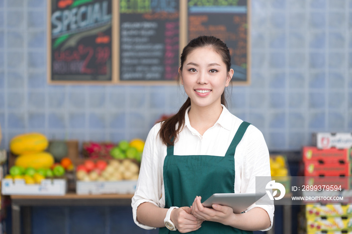 young pretty woman works in fruit store