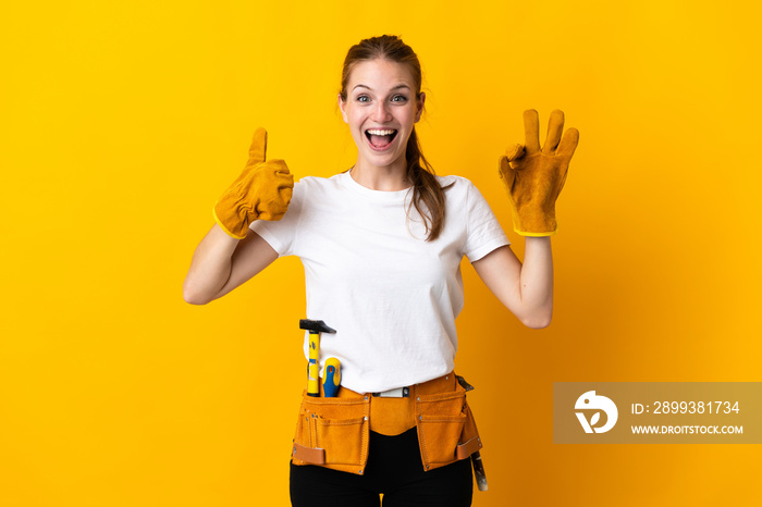 Young electrician woman isolated on yellow background showing ok sign and thumb up gesture