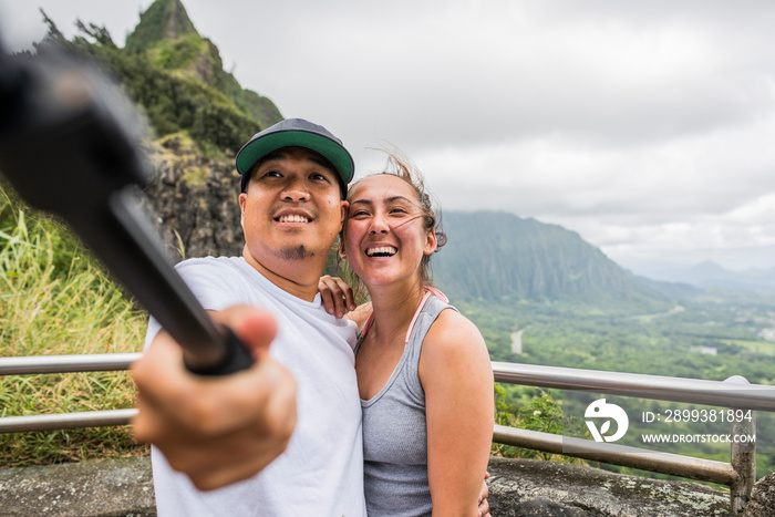 美国夏威夷瓦胡岛努瓦努·帕利，一对年轻夫妇从观景台上指着