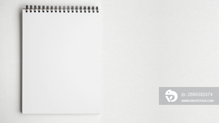 白色桌子背景上的空白纸质记事本。