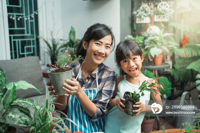 在家里的花园里种植时，心情愉快的母亲和女儿