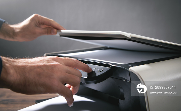 Man copying and scanning documents in office.