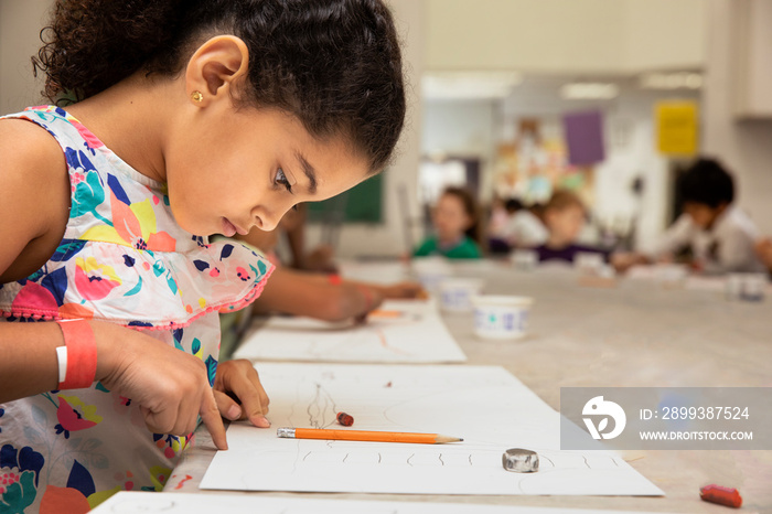 Young girl drawing in a classroom