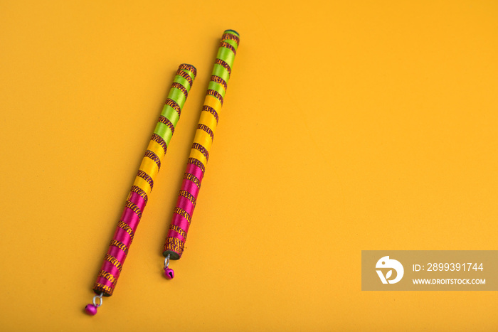 Dandiya sticks on a yellow background. Raas Garba or Dandiya Raas is the traditional folk dance form