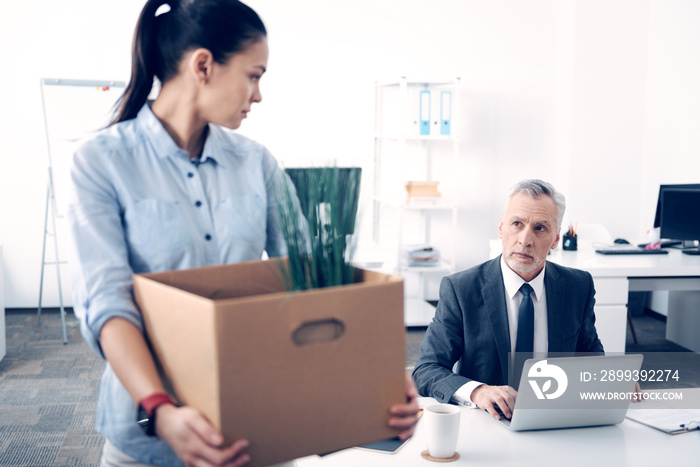 Mature boss looking at his employee leaving office