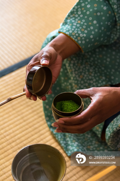African American woman guest hands holding chashaku bamboo matcha tea spoon and opens Natsume lacque
