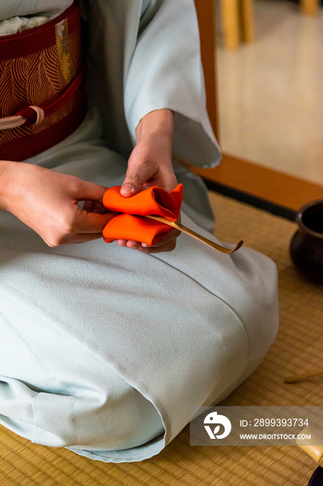日本女人，茶艺大师，Sen Rikyu，用一块橙色的净化布洗手