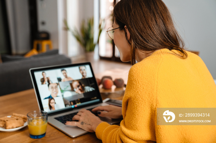 Happy woman smiling and having video call on laptop in apartment