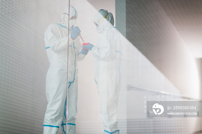 Biochemists in clean suits working in laboratory