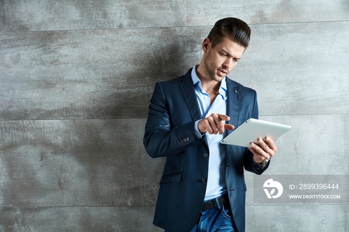 Confident businessman using tablet at office