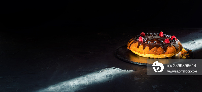 Tasty chocolate cake with fresh berries on dark background. Space for text