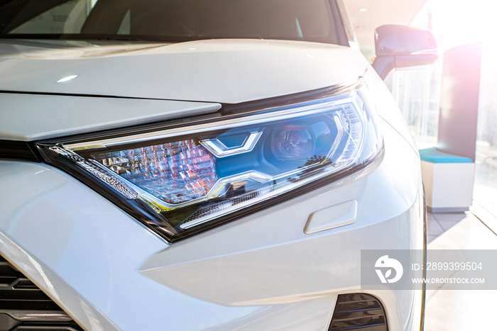 headlight of a new car in the cabin in the sun. car background close-up.