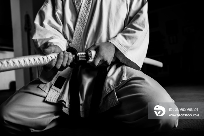 年轻武术家的特写，武士刀坐在seiza位置，黑白相间。