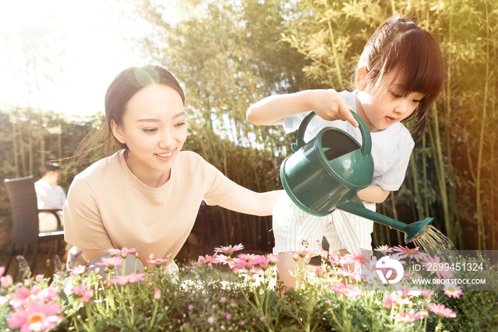 年轻的母亲和女儿在浇花