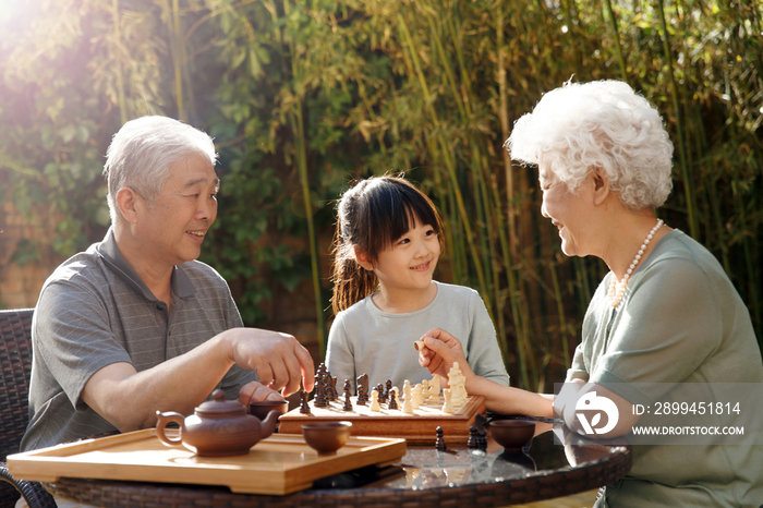 老年夫妇和孙女在院子里下棋