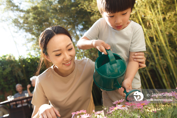 母亲和儿子在花园里浇花