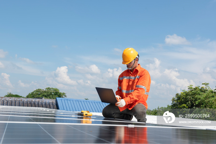 Asian technician Solar panels with a drill to install solar panels on the roof.