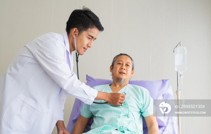 Elderly patient man unhappy, suffer, sadness from sick looking forward and doctor using stethoscope on heart. Doctor or nurse take care senior patient health admission at hospital