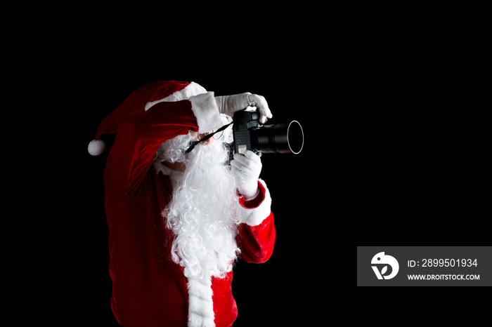 Santa claus taking picture with his camera isolated on black