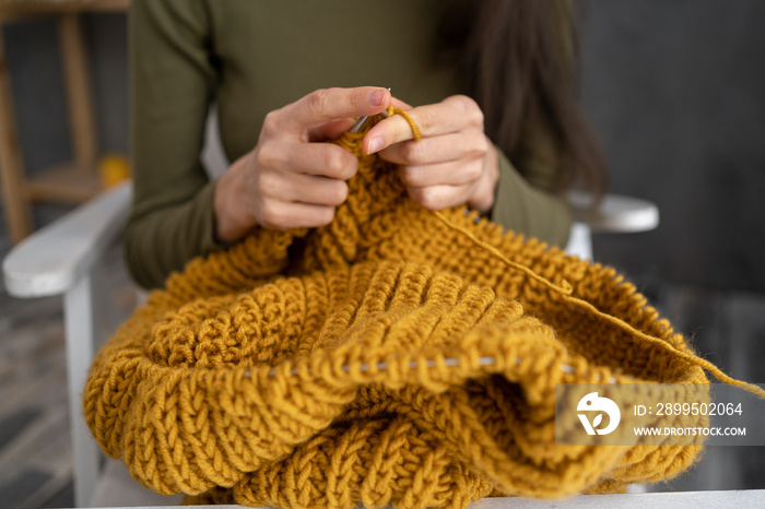 Closeup of knitting hands, knits woolen clothes, Woman knits sweater