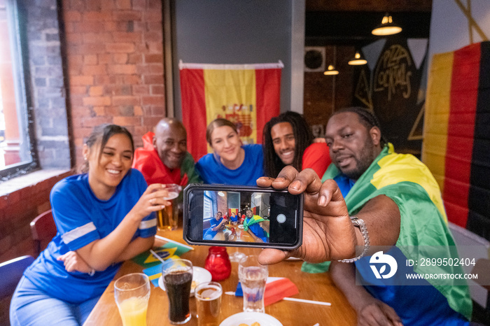 Group of friends taking selfie in pub