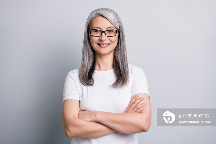 Photo of retired old woman toothy smile folded hands wear eyeglasses white t-shirt isolated grey color background