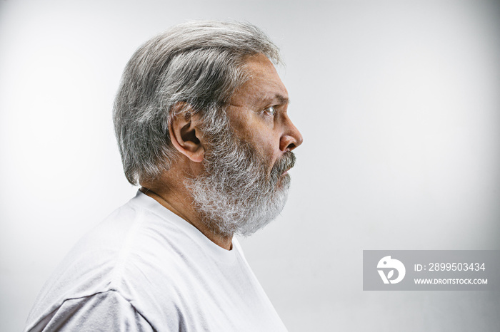 The senior attractive man looking suprised isolated on white