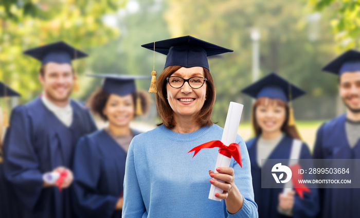 graduation, adult education and old people concept - happy senior graduate student woman in mortar board with diploma laughing over group of classmates in summer park background