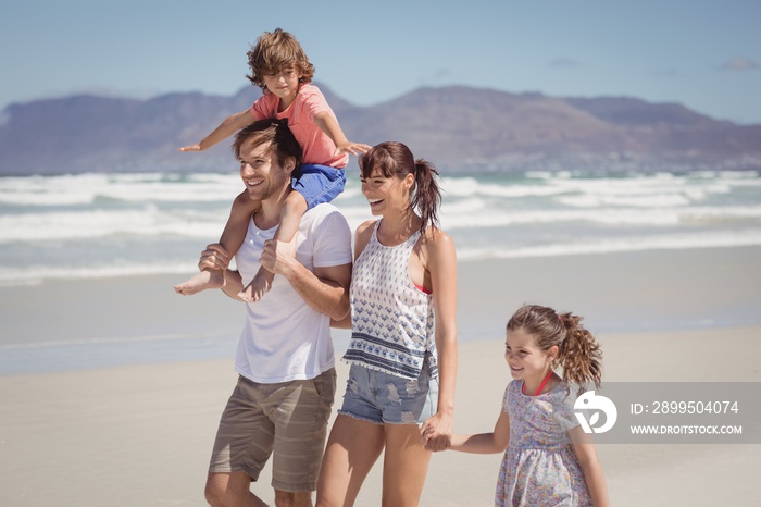 Happy family walking at beach